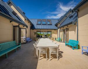 a large patio with a long table and benches at Beachfront Paradise - Opito Bay Holiday Home in Opito Bay