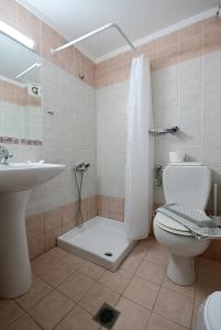 a bathroom with a toilet and a shower and a sink at VILLA CARIATIS in Nea Kallikrateia