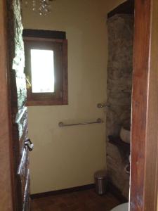 baño con ventana y pared de piedra en B&B Mulino Marsa, en CastellʼArquato