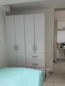 um quarto branco com armários brancos e uma cama em Ribera Alta em Barranquilla