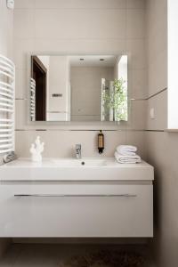 a white bathroom with a sink and a mirror at Villa Odskocznia Apartamenty Zakopane in Zakopane
