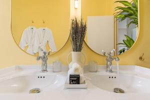 bagno con lavandino bianco e specchio di Appartement cosy Rouen Rive droite a Rouen