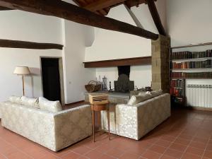 un soggiorno con due divani e una cucina di Casale borgo le paline a Borgo alla Collina