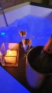 a table with two wine glasses and a candle on it at Villa Malvasio Retreat & Spa in Sassari