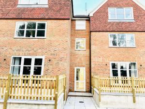 a brick building with a wooden fence in front of it at Stylish Dover Apt With Castle View in Kent