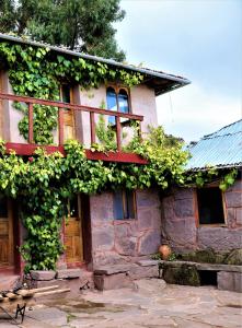 a house with vines growing on the side of it at BLUE SKY Lodge Taquile in Huillanopampa