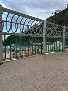 um portão de metal com uma piscina ao fundo em L'oasi di copanello em Copanello