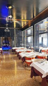 Hotel oro في تْشينتو: غرفة طعام بها طاولات وكراسي وثريا