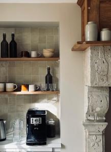 a kitchen with a coffee maker on a shelf at La suite in Sainte-Mère-Église