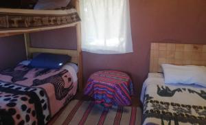 a small room with two beds and a window at BLUE SKY Lodge Taquile in Huillanopampa