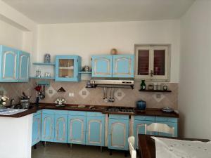 une cuisine avec des placards bleus et un comptoir dans l'établissement L'oasi di copanello, à Copanello