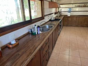 a kitchen with a wooden counter top and a sink at casa de campo in Punta Indio