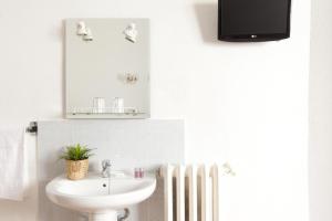 a bathroom with a sink and a toilet and a tv at Hostal Condestable in Madrid