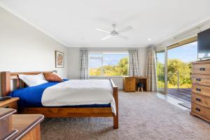 a bedroom with a bed and a large window at RidgeRaj - Kerikeri Holiday Home in Kerikeri