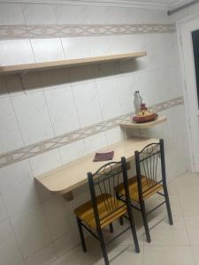 a table and two chairs with a table and shelves at Apartamento exclusivo in Tangier