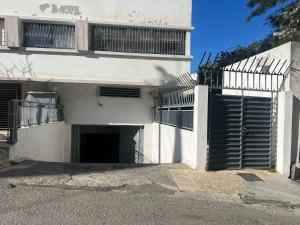 a white house with a gate and a garage at Apartamento exclusivo in Tangier