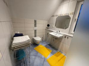 a bathroom with a sink and a toilet and a mirror at Ferienhaus- Dallgow in Dallgow +21 photos