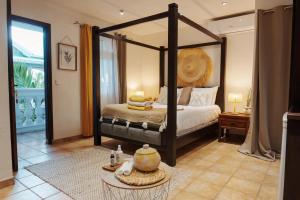 um quarto com uma cama de dossel e uma mesa com toalhas em Villa Kapresse du 978 - Guest house em Saint Martin