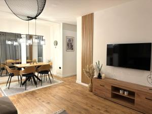 a living room with a dining table and a flat screen tv at PineTree Jahorina in Jahorina