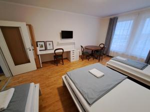 a room with two beds and a table and a television at Apart Sudenburg / Magdeburg in Magdeburg