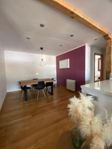 ein Esszimmer mit einem Holztisch und einer lila Wand in der Unterkunft Dúplex Markina Xemein in Marquina