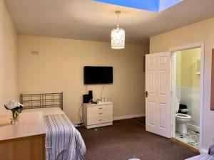 a bedroom with a bed and a flat screen tv at Prestashortstays in Belfast