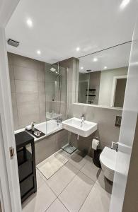 łazienka z umywalką, wanną i toaletą w obiekcie Luxury 1 bedroom Apartment in London overseeing Canary Wharf with free parking w Londynie