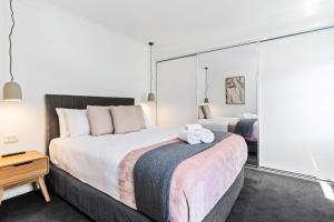 オレンジにあるRobinia Guest House - Warmth & Minimalismの大きなベッドとタオル2枚のある寝室