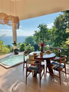 a dining room with a table and chairs and a pool at Monkey House in Dominicalito