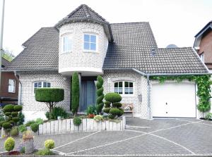 a white brick house with a white garage at FEWO EMMA in Overath