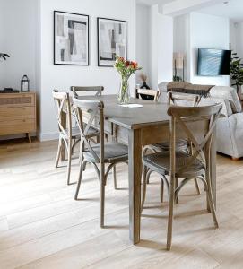 a dining room with a wooden table and chairs at Salters Cottage - Stunning Modernised 3 BR Home Just Steps From the Beach in Budleigh Salterton