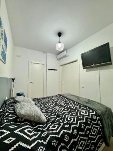 een slaapkamer met een bed en een flatscreen-tv bij Loft 1 hab. Parking mediano. Terrassa, Barcelona in Terrassa