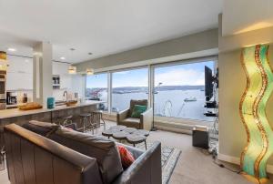 a large living room with a view of the water at NewMark Tower’s Water Wheel Condo with Sea Views in Seattle