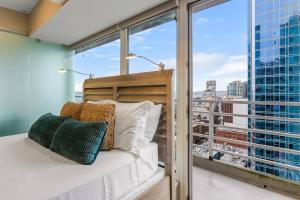 a bedroom with a bed and a large window at NewMark Tower’s Water Wheel Condo with Sea Views in Seattle