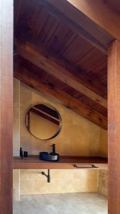 een badkamer met een wastafel en een spiegel bij La Caseta in Arnés