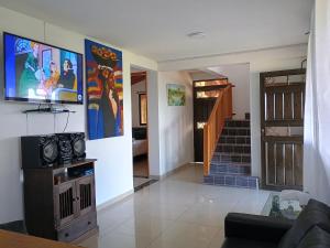 a living room with a tv on a wall at Finca con vista al embalse y jacuzzi in Guatapé