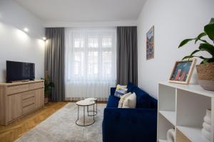 een woonkamer met een blauwe bank en een tv bij Old Town Apartment Kazimierz in Krakau