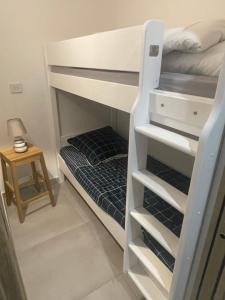 ein Schlafzimmer mit einem Etagenbett und einem kleinen Tisch in der Unterkunft Le Galatee -T2 luxe les pieds dans l'eau - Porticcio in Grosseto-Prugna