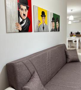 ein Wohnzimmer mit drei Gemälden an der Wand in der Unterkunft Casa Andrew in Terrasini