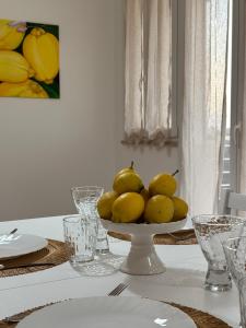 een tafel met een kom citroenen op een bord bij Casa Andrew in Terrasini