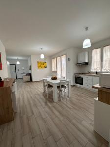 a living room with a table and a kitchen at Casa Andrew in Terrasini