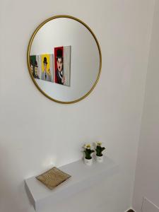 einen Spiegel an einer weißen Wand über einer weißen Badezimmertheke in der Unterkunft Casa Andrew in Terrasini