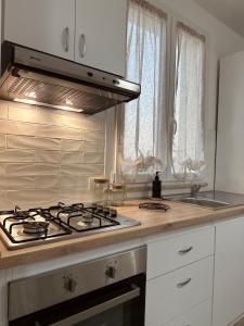 een keuken met een fornuis top oven naast een raam bij Casa Andrew in Terrasini