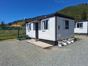 a tiny house with a picnic table and a bench at Picton's Waikawa Bay Holiday Park in Picton