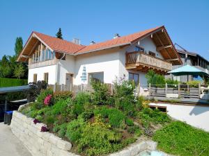 una casa con un jardín delante de ella en Chiemsee Living, en Chieming