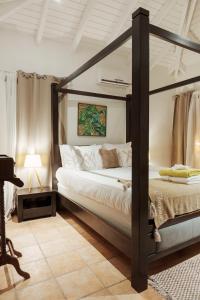 um quarto com uma cama de dossel num quarto em Villa Kapresse du 978 - Guest house em Saint Martin