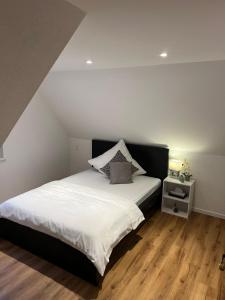 1 dormitorio con 1 cama grande con sábanas blancas en Ferienwohnung Eislingen, en Eislingen