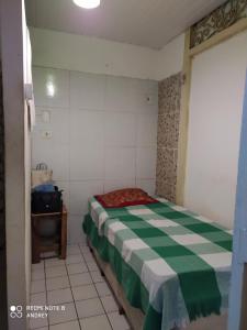 a small bedroom with a green and white bed at Flora Pousada in Recife