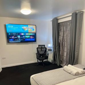 a room with a bed and a tv on the wall at Home Away from Home 