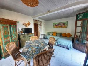 Zimmer mit einem Tisch, Stühlen und einem Bett in der Unterkunft Appartement Papay dans Villa Fleurs des Iles in Le Vauclin